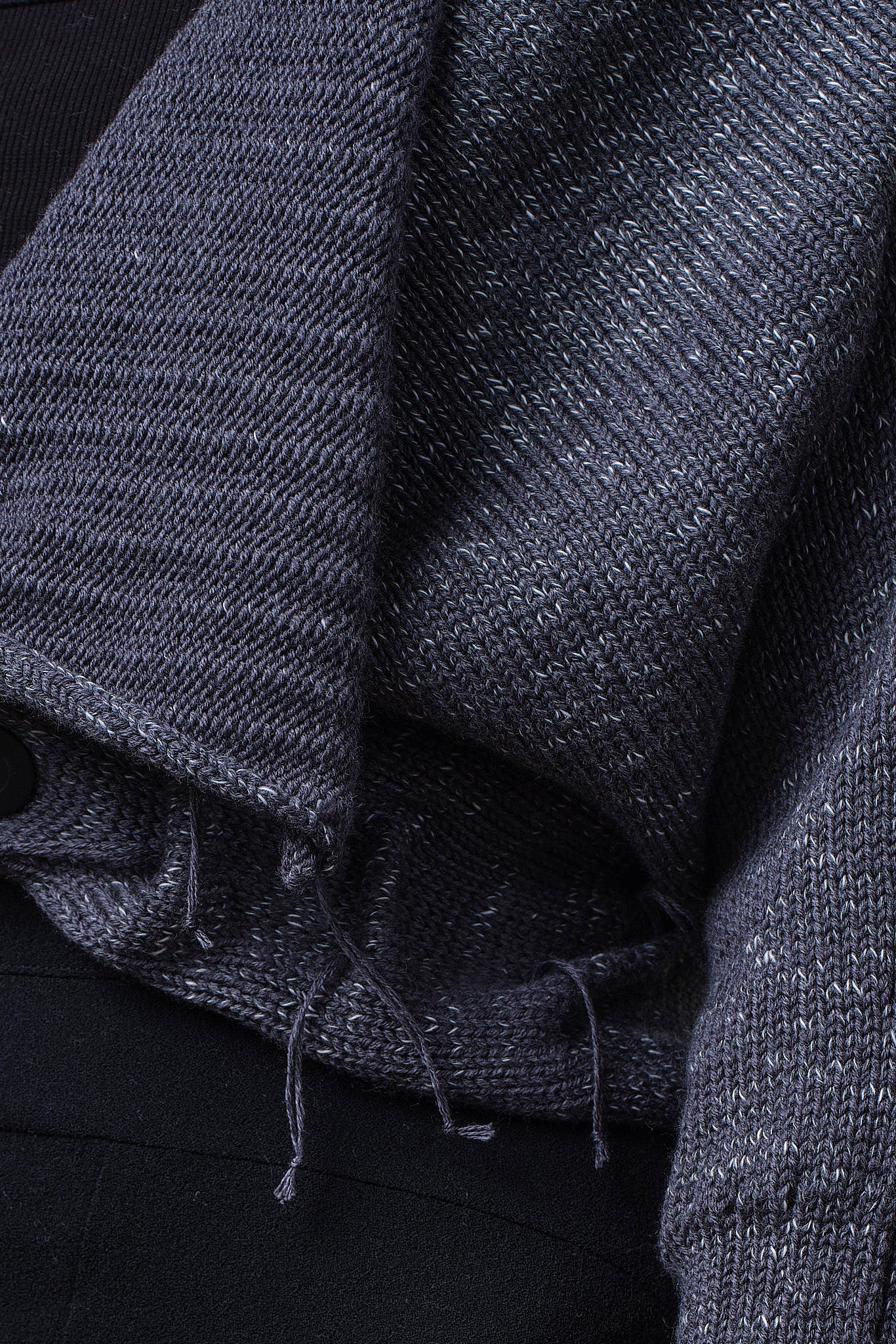 Close up fabric view of grey with white flecked wool ruched cardigan.