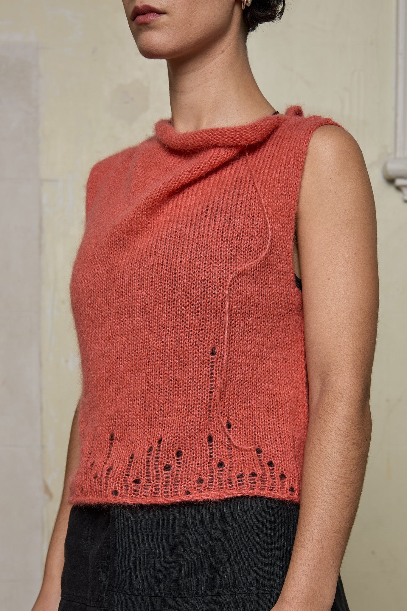 Side view of model wearing super lush knitted vest in carrot colourway, designed and knitted in Melbourne by Wendy Voon knits