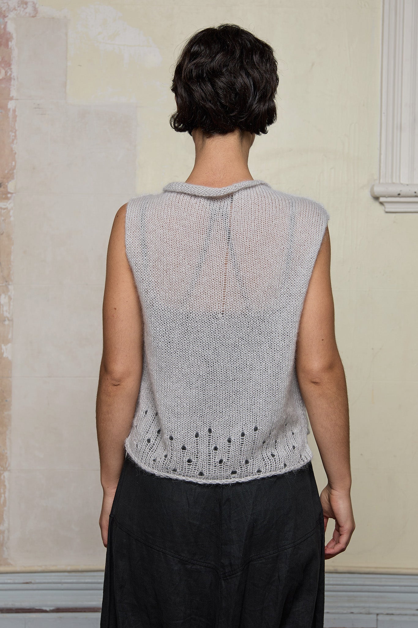 Back view of model wearing super lush knitted vest in soft grey colourway, designed and knitted in Melbourne by Wendy Voon knits