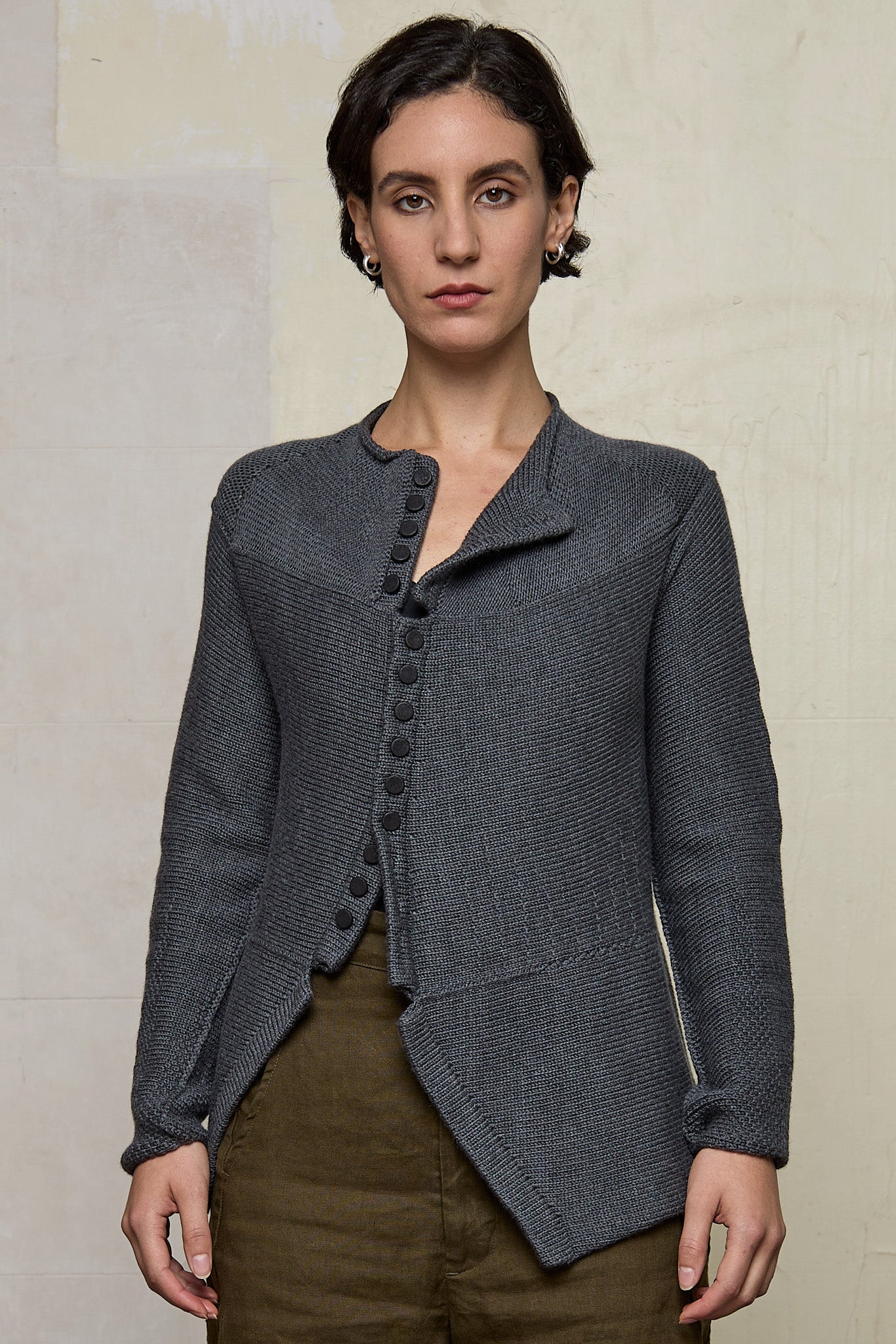 Model wears knitted peplum riding coat in steel grey, featuring vintage cloth covered buttons.  Made from superfine merino.