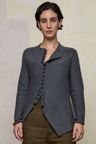 Model wears knitted peplum riding coat in steel grey, featuring vintage cloth covered buttons.  Made from superfine merino.