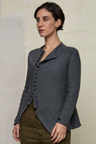 Model wears knitted peplum riding coat in steel grey, featuring vintage cloth covered buttons.  Made from superfine merino.