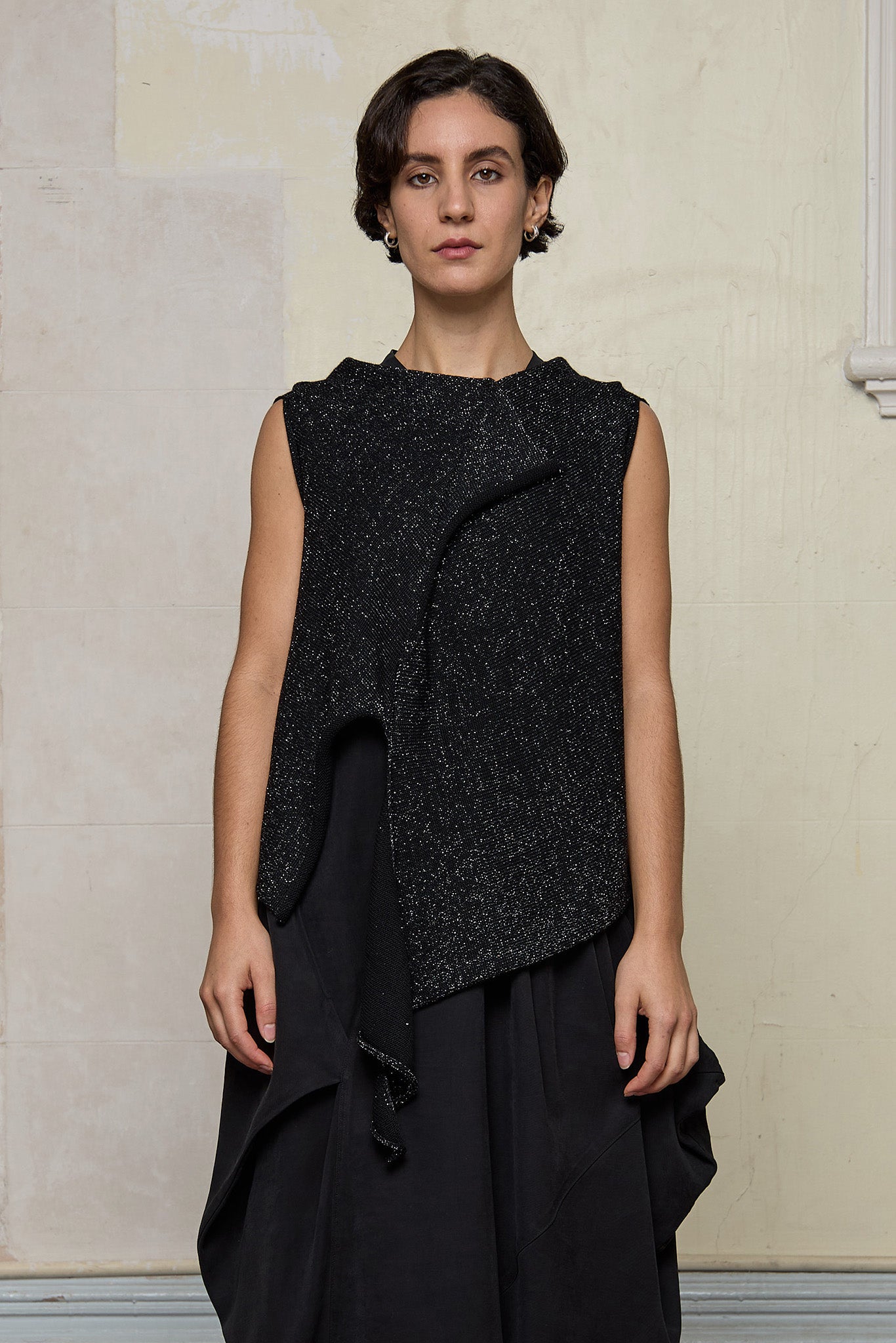 Model wears asymmetric self-curling vest in silver metallic on black merino wool vest, designed and knitted in Melbourne by Wendy Voon knits