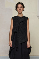 Model wears asymmetric self-curling vest in silver metallic on black merino wool vest, designed and knitted in Melbourne by Wendy Voon knits
