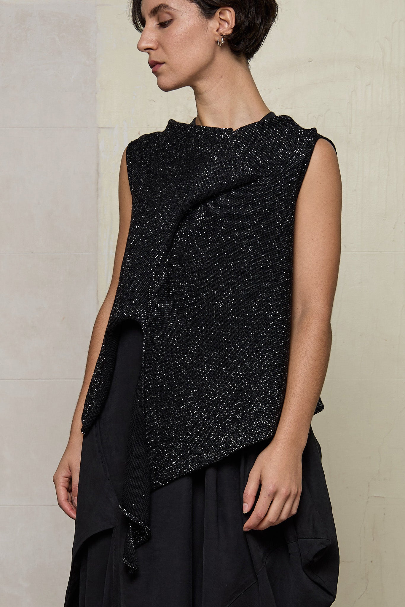 Model wears asymmetric self-curling vest in silver metallic on black merino wool vest, designed and knitted in Melbourne by Wendy Voon knits