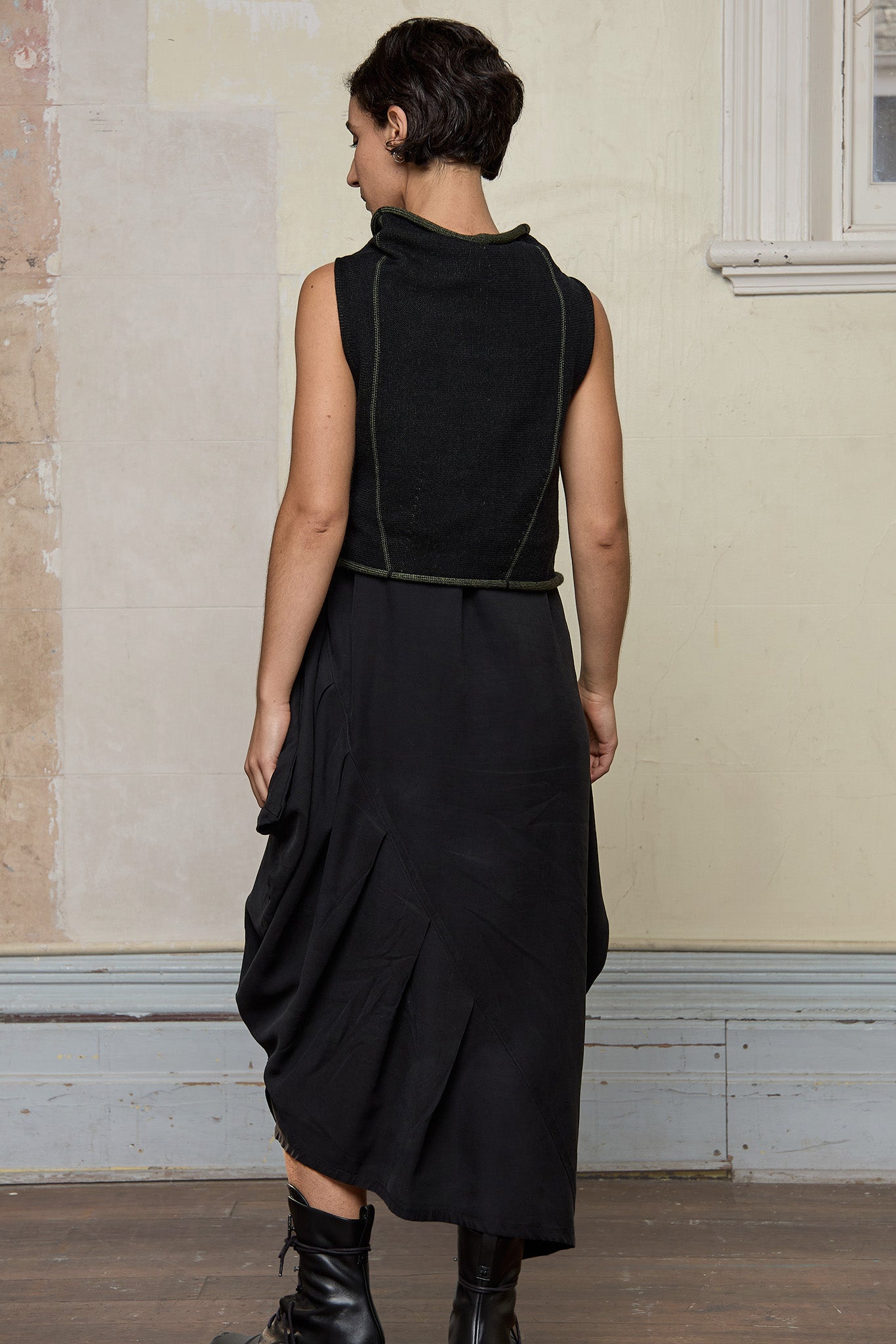 Model wears knitted asymmetric self-curling vest inside out, in army green on black colourway. Designed and knitted in Melbourne by Wendy Voon knits.