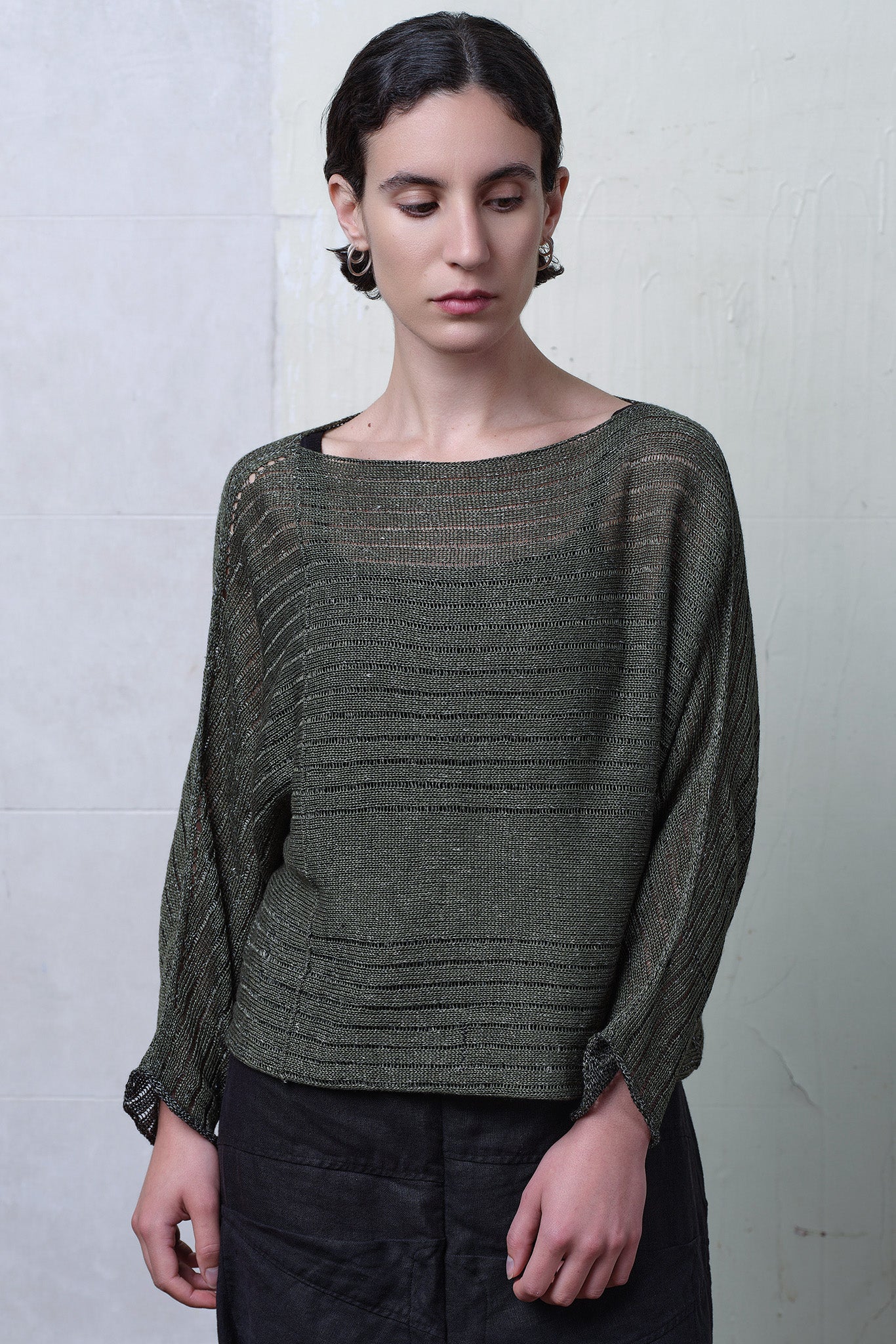 Model wears linen/cotton batwing in army backed with black and white flecked colourway. Designed and knitted in Melbourne  by Wendy Voon knits