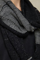 Close up fabric view of black and white infinity scarf, made from alpaca, merino wool and cotton