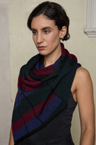Model wears multii-coloured striped infinity loop scarf, designed and knitted in Melbourne by Wendy Voon Knits.