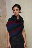 Model wears multii-coloured striped infinity loop scarf, designed and knitted in Melbourne by Wendy Voon Knits.
