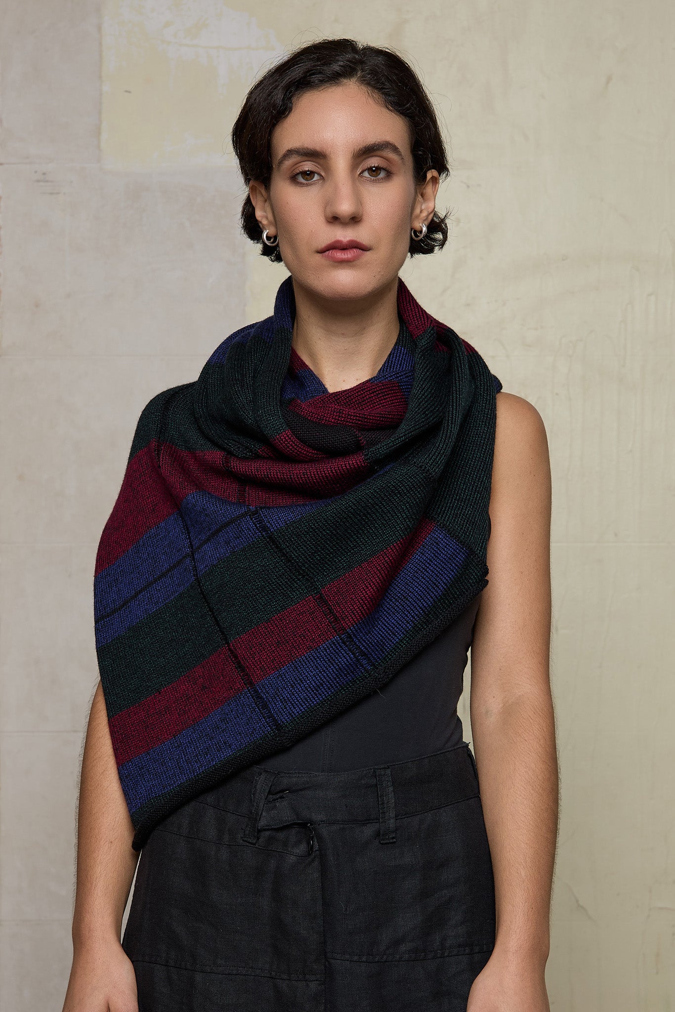 Model wears multii-coloured striped infinity loop scarf, designed and knitted in Melbourne by Wendy Voon Knits.