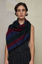 Model wears multii-coloured striped infinity loop scarf, designed and knitted in Melbourne by Wendy Voon Knits.