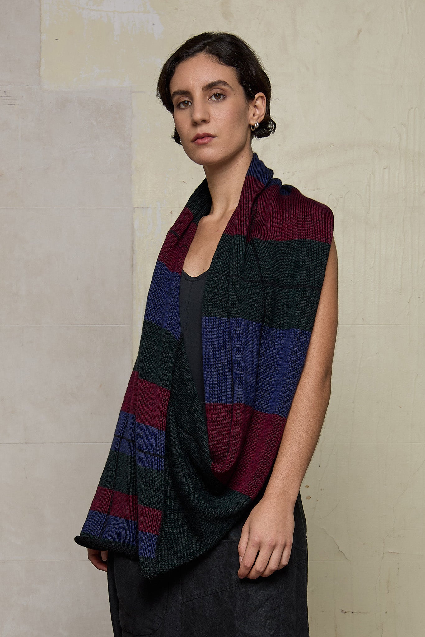 Model wears multii-coloured striped infinity loop scarf, designed and knitted in Melbourne by Wendy Voon Knits.
