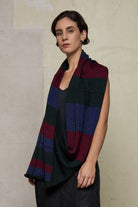 Model wears multii-coloured striped infinity loop scarf, designed and knitted in Melbourne by Wendy Voon Knits.