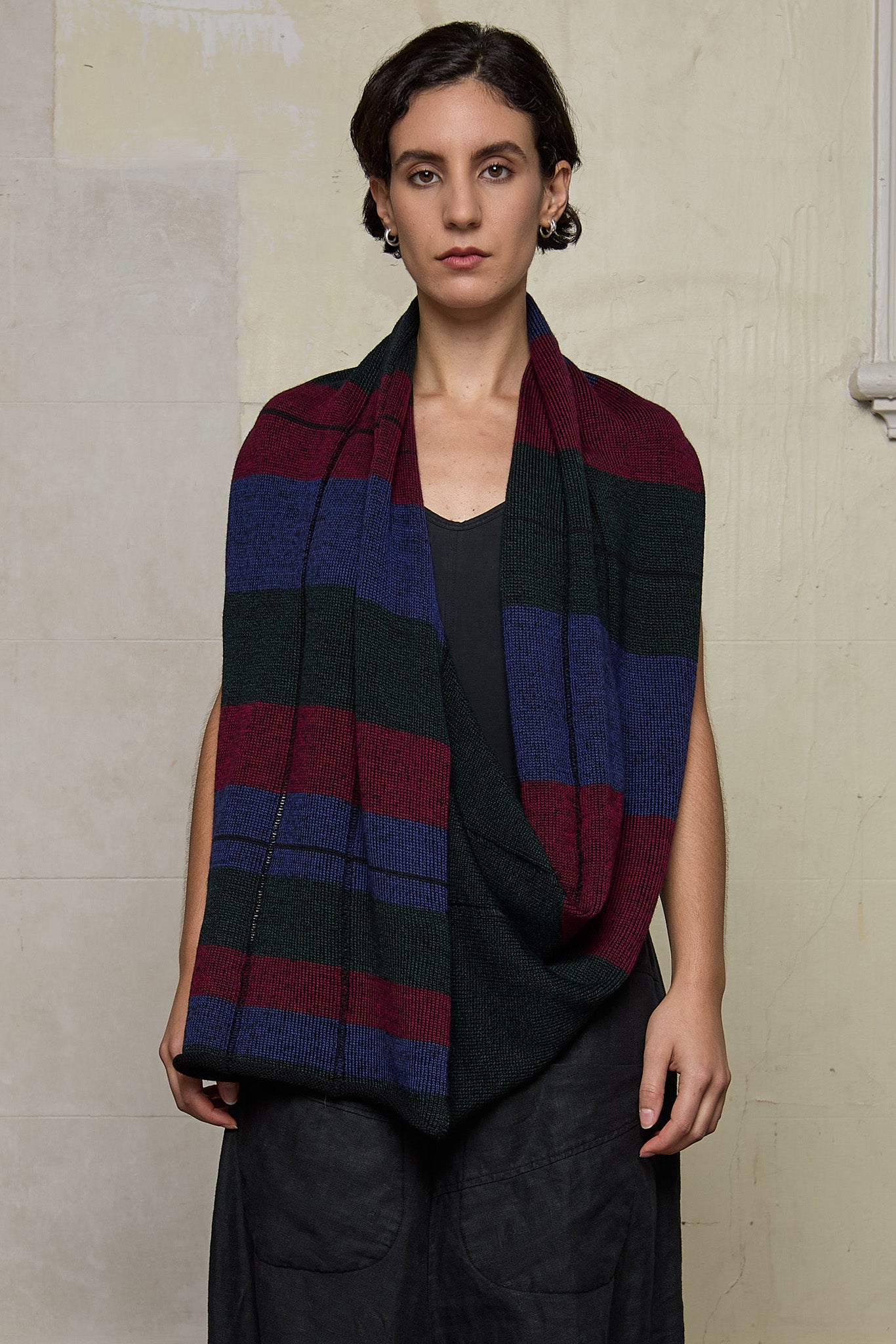 Model wears multii-coloured striped infinity loop scarf, designed and knitted in Melbourne by Wendy Voon Knits.