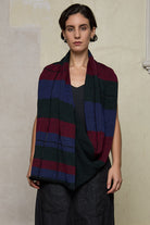 Model wears multii-coloured striped infinity loop scarf, designed and knitted in Melbourne by Wendy Voon Knits.