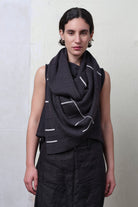 Model wears superfine merino linework scarf featuring off white stripe detail on charcoal. Designed and knitted in Melbourne by Wendy Voon knits