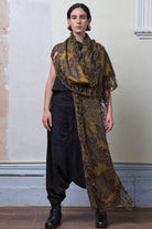 Model wears knitted damask scarf in a grey and gold colourway.