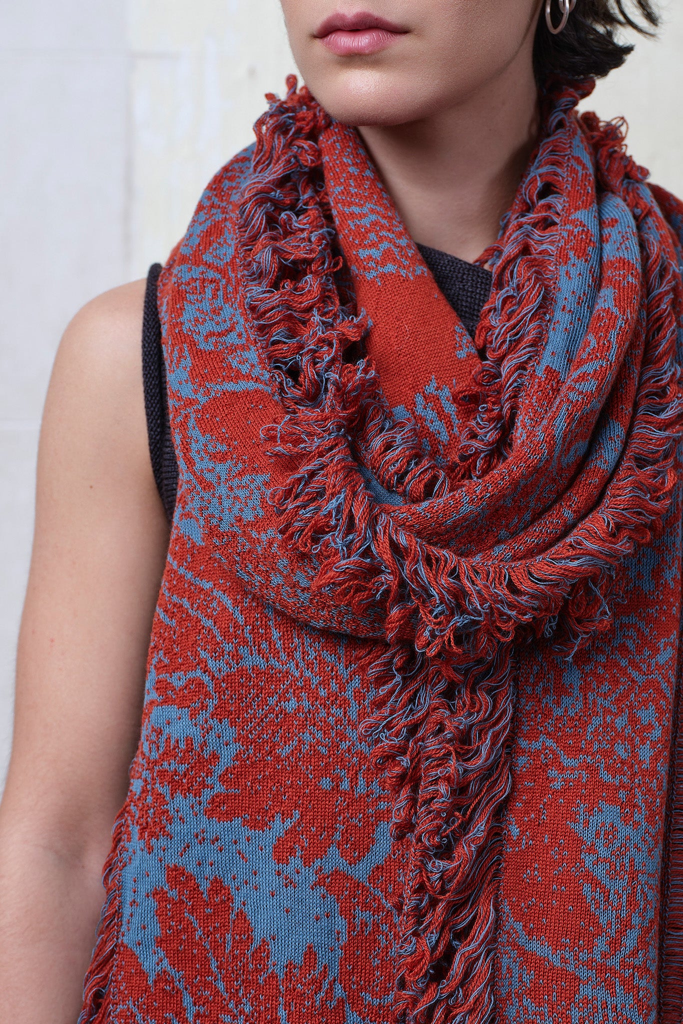 Close up fabric view of knitted wool/linen/cotton damask scarf in rust and lagoon blue colourway.