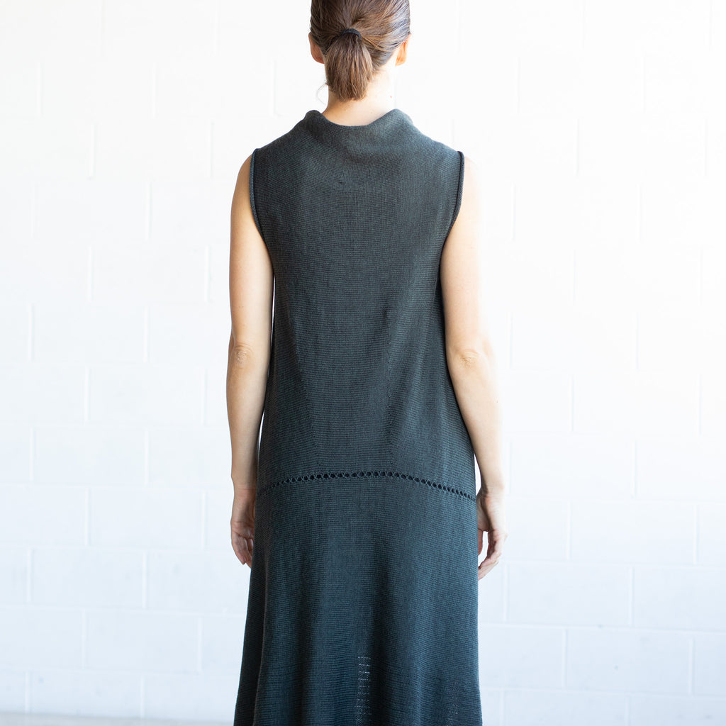 Back view of Asymmetric Longline vest design by Wendy Voon knits in deep forest green merino, with seam and stitch detail