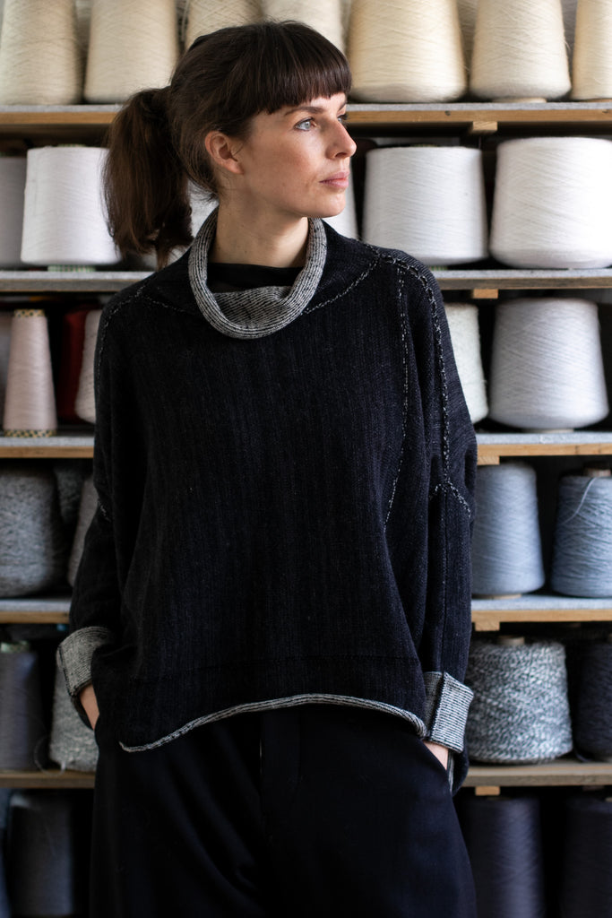 Front view of reversible box shaped jumper designed by Wendy Voon, made from superfine merino wool, with black colourway showing.