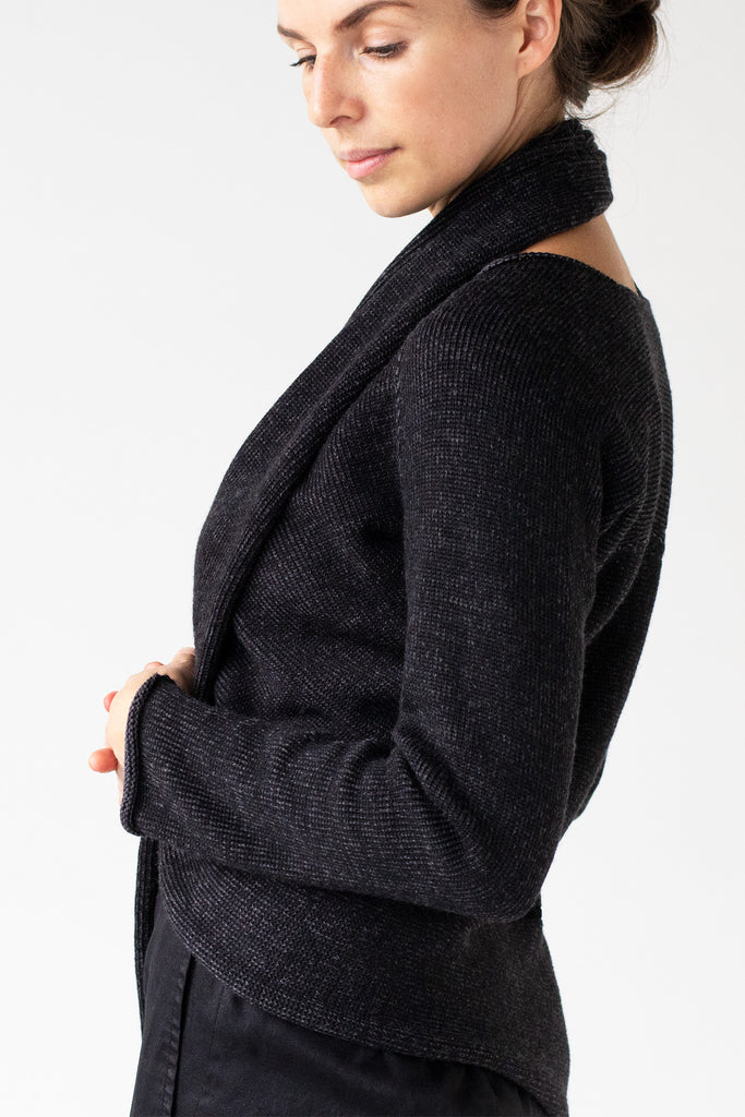 Side detail view of the Merino Cross Over, shown in charcoal and black fleck worn with front looped around the neck as a cardigan