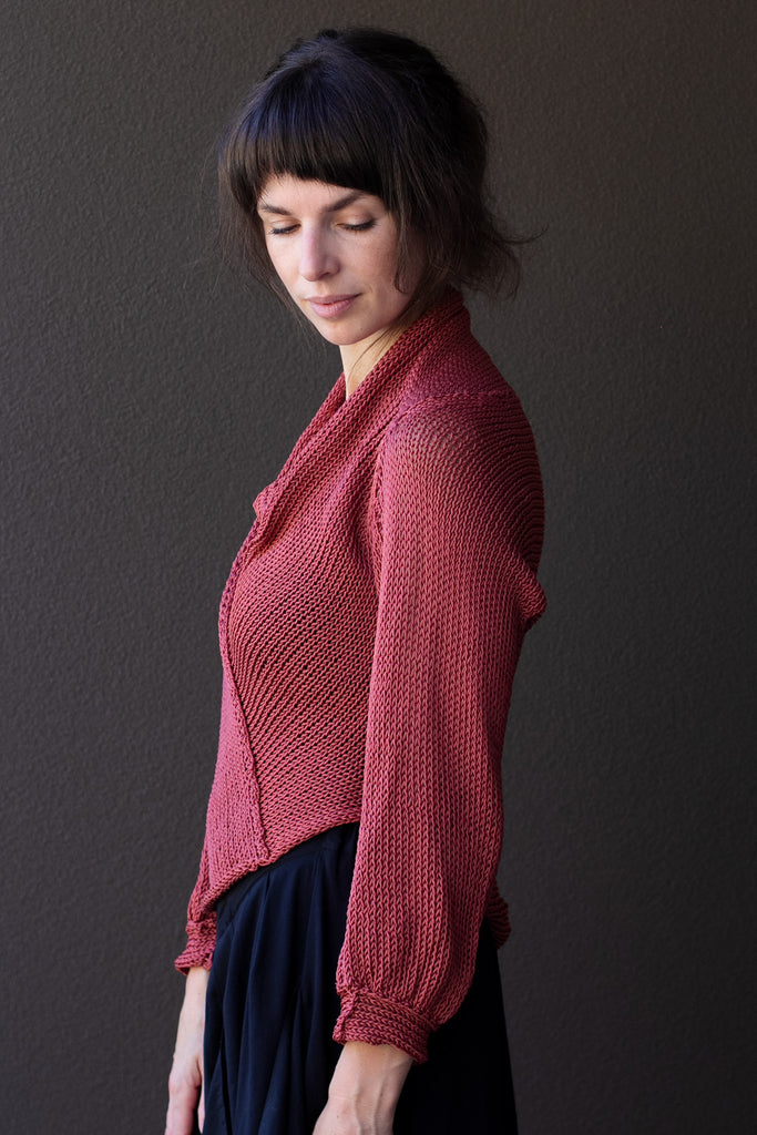 Side profile of model wearing coral cotton cowl neck jumper, designed  and knitted in Melbourne by Wendy Voon knits