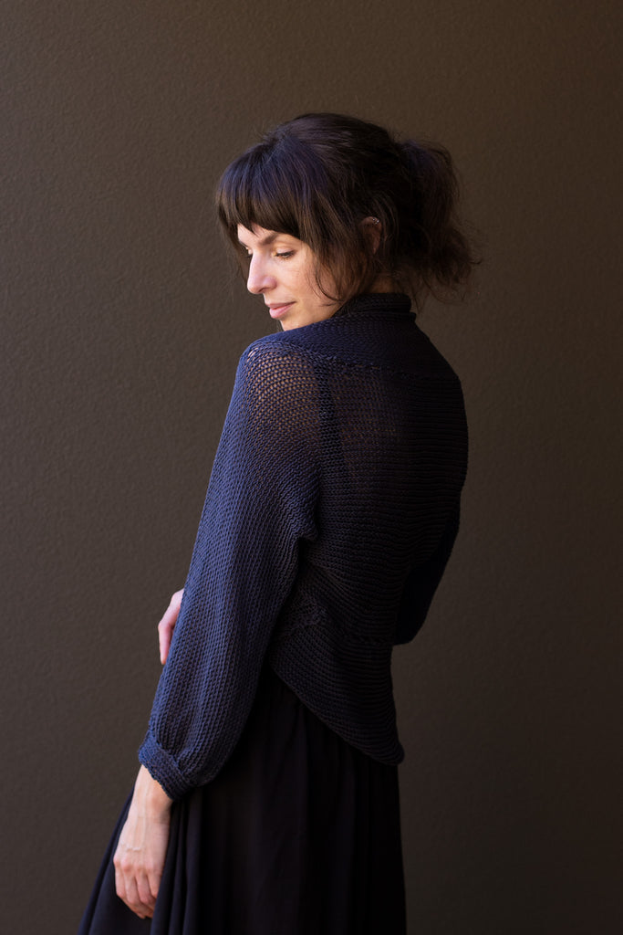Side profile of model wearing slate cotton cowl neck jumper, designed  and knitted in Melbourne by Wendy Voon knits