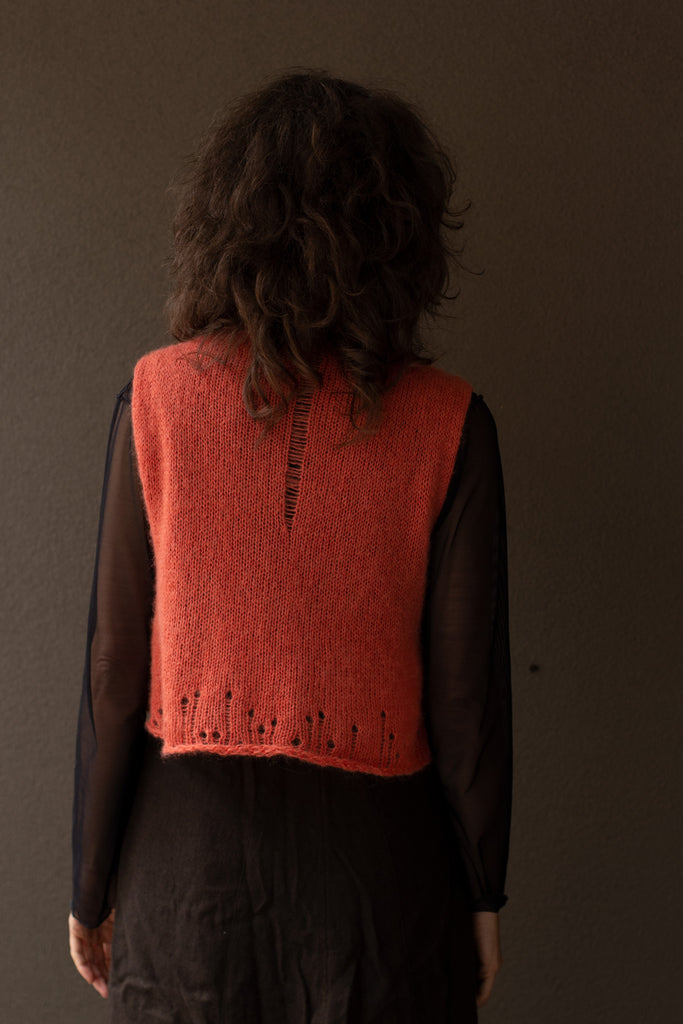Back view of super soft knitted vest in a carrot colourway, featuring laddered laceholes, made from baby alpaca, mohair and silk. Designed and made in Melbourne by Wendy Voon knits