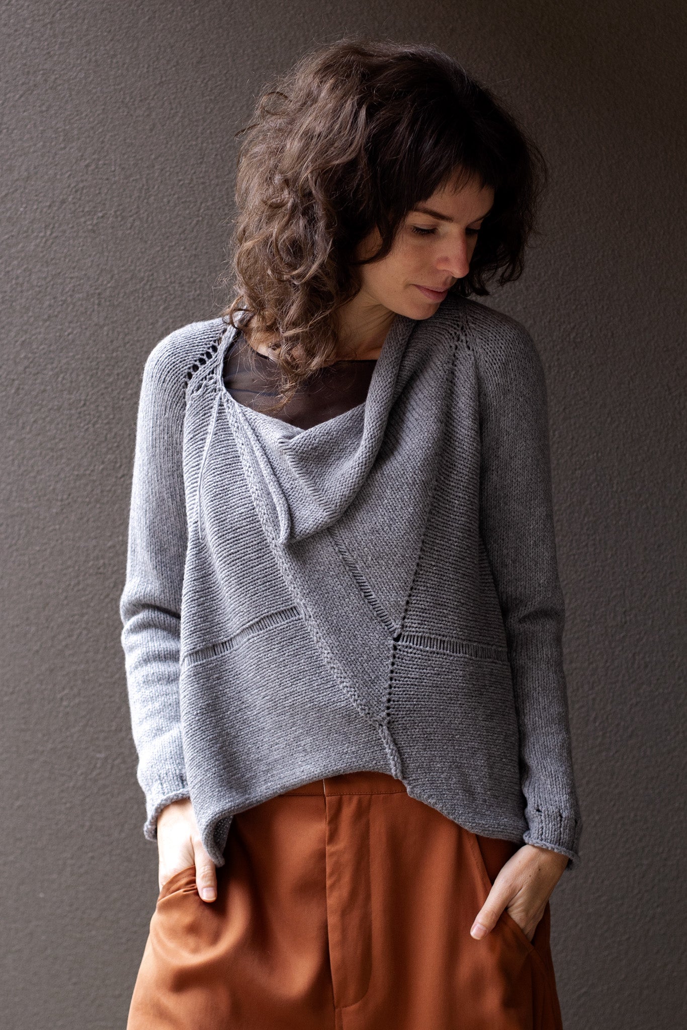 Front view of  superfine merino wool/polyamide soft grey jumper, designed by Wendy Voon knits, made in Melbourne.  Jumper features triangular panels at front with loose threads left as design feature