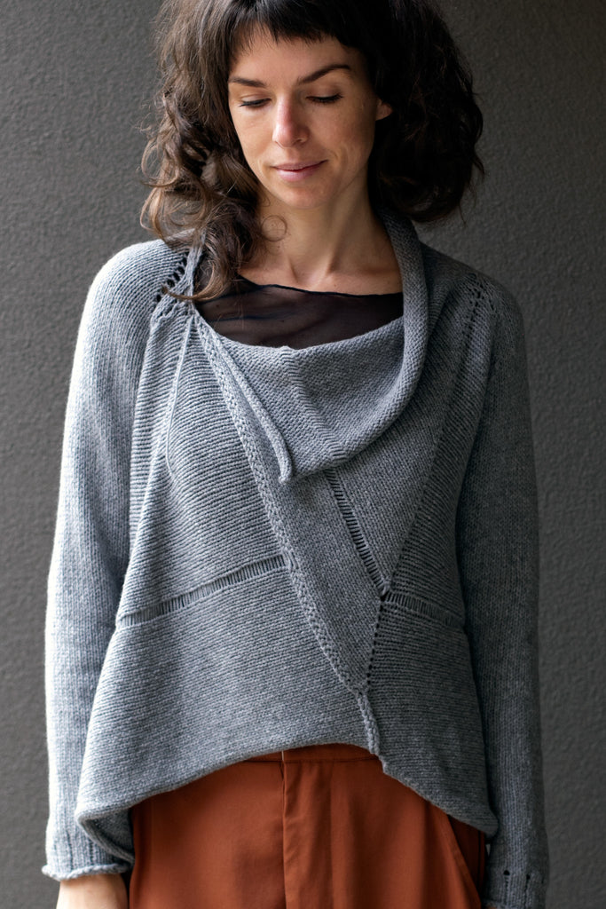 Front view of  superfine merino wool/polyamide soft grey jumper, designed by Wendy Voon knits, made in Melbourne.  Jumper features triangular panels at front with loose threads left as design feature