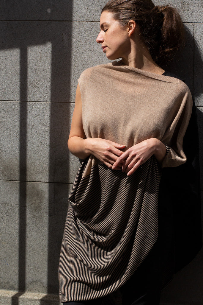 Front view of Striped Wrap design by Wendy Voon knits in black and oatmeal merino wool, worn as asymmetric poncho