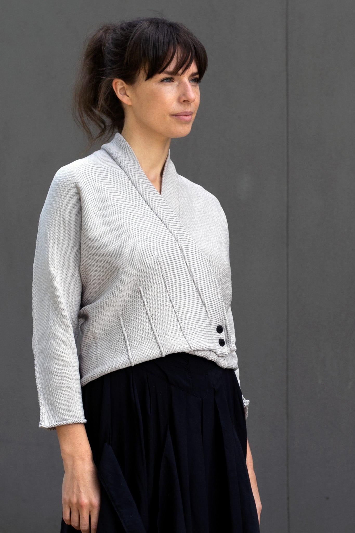 Three quarter profile view of buttoned welted cotton cardi in pearl colourway, designed and made in Melbourne by Wendy Voon Knits