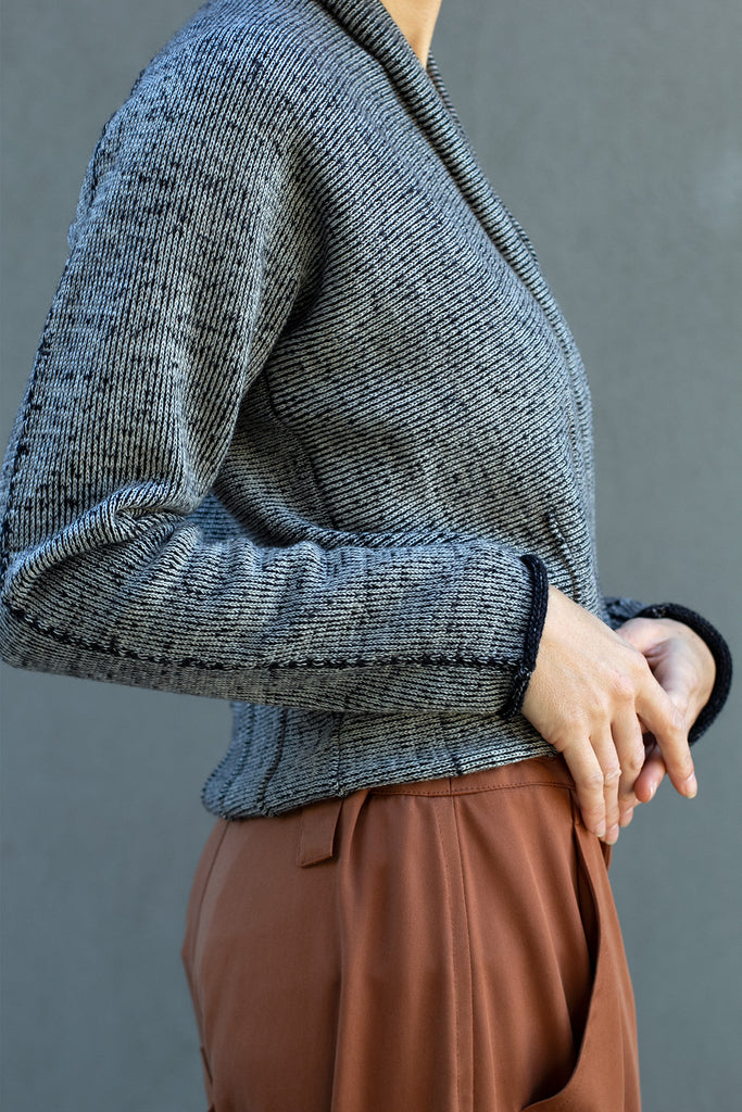 Side view of welted wool cardigan buttoned up in cream, charcoal/black colourway