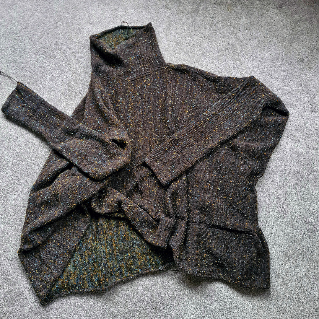 Dark gray textured sweater on a gray surface