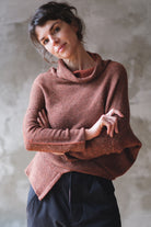 Model wears wool bias knit jumper in terracotta flecked colourway.
