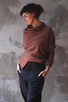 Model wears wool bias knit jumper in terracotta flecked colourway.