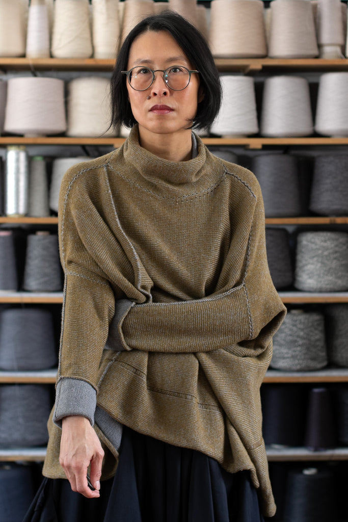 Front view of model wearing a wool boxed shaped jumper in mustard backed with grey merino wool, designed and made in Melbourne by Wendy Voon knits.
