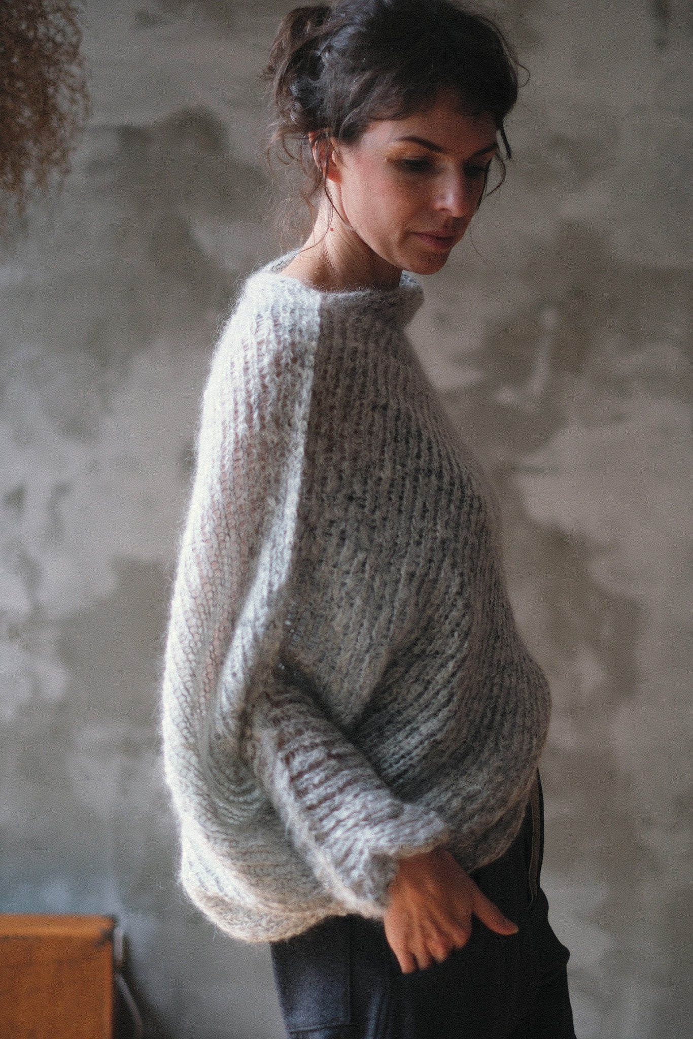 Model wears a mohair cocoon sleeved jumper in a natural colour.
