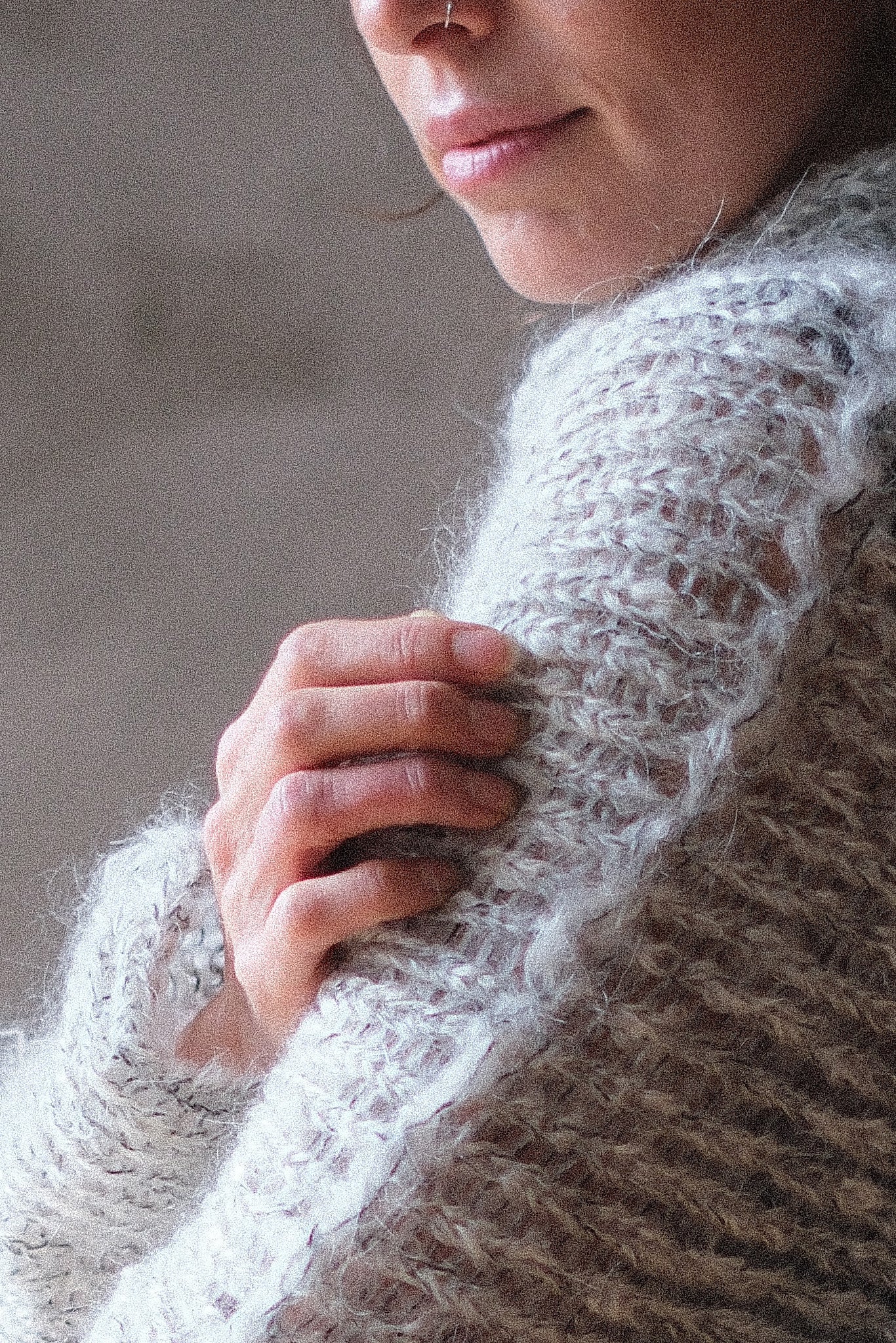 Close up of a mohair cocoon sleeved jumper in a natural colour.