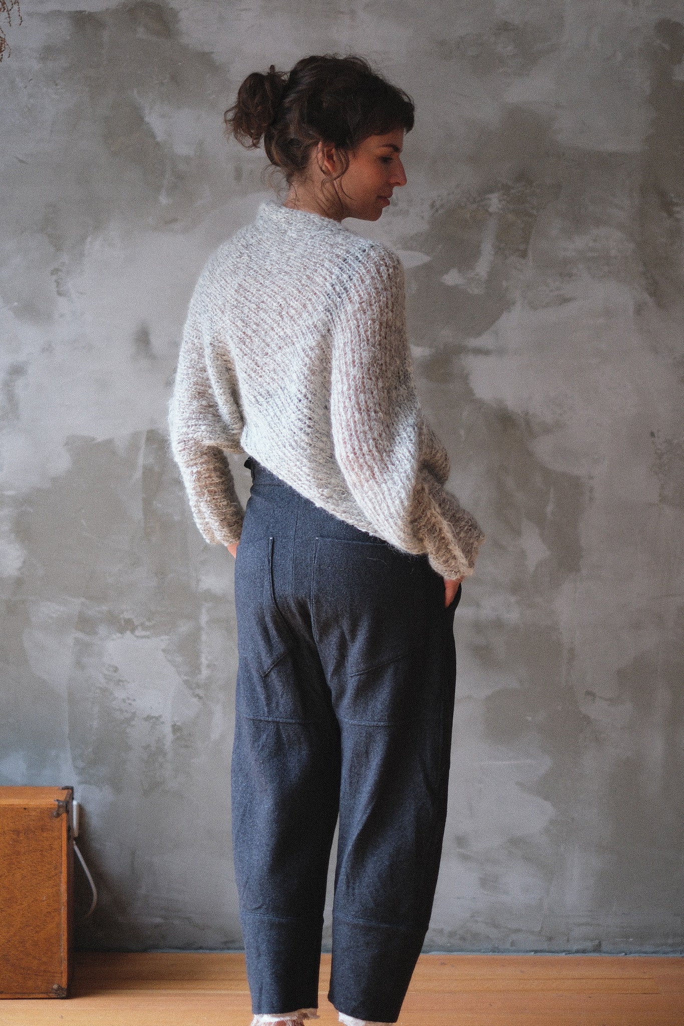 Back view of model wearing a mohair cocoon sleeved jumper in a natural colour.