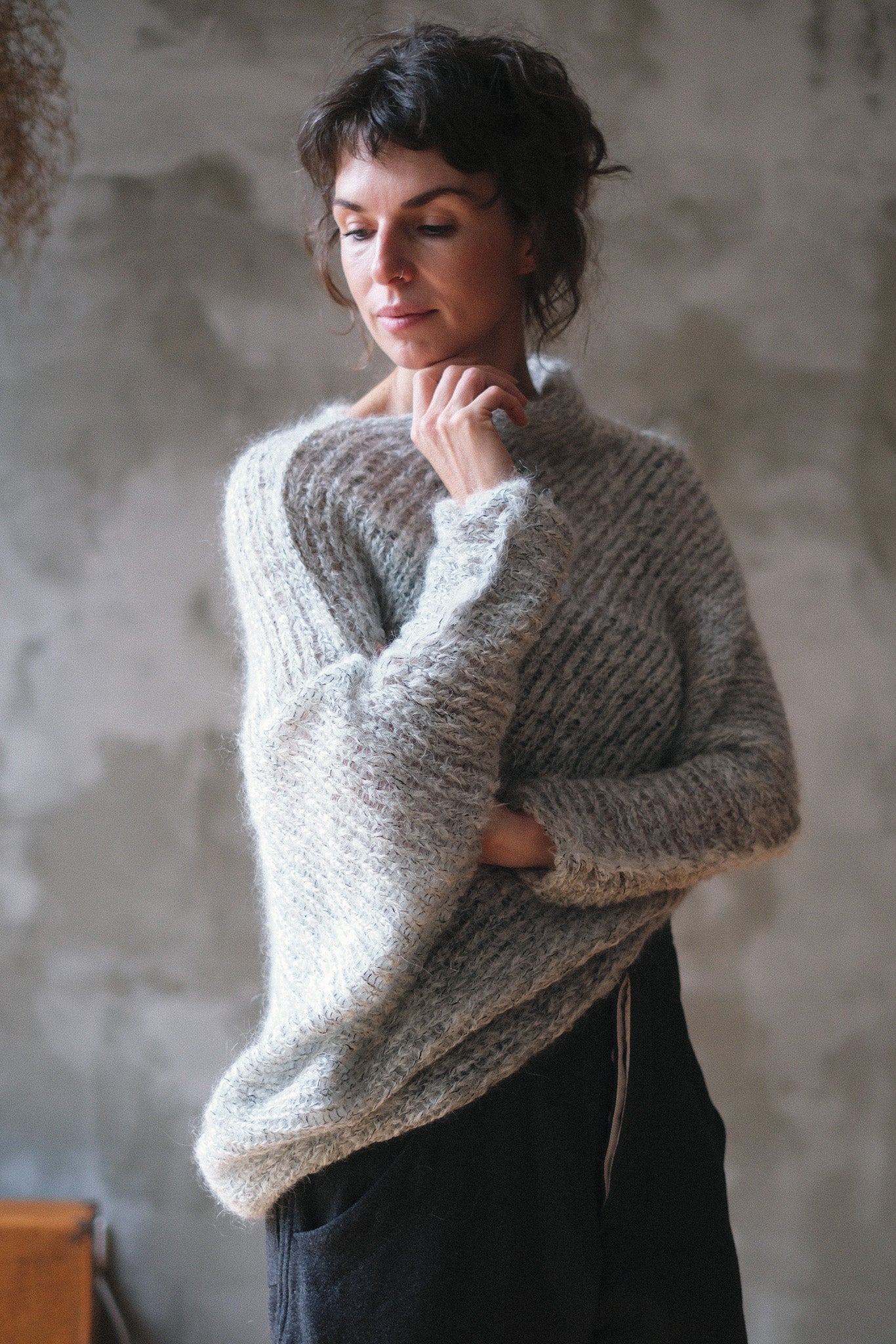 Model wears a mohair cocoon sleeved jumper in a natural colour.