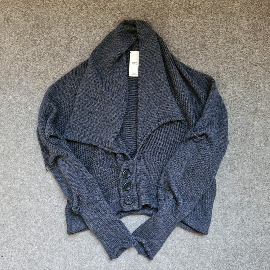 Charcoal knitted cardigan on a beige carpet