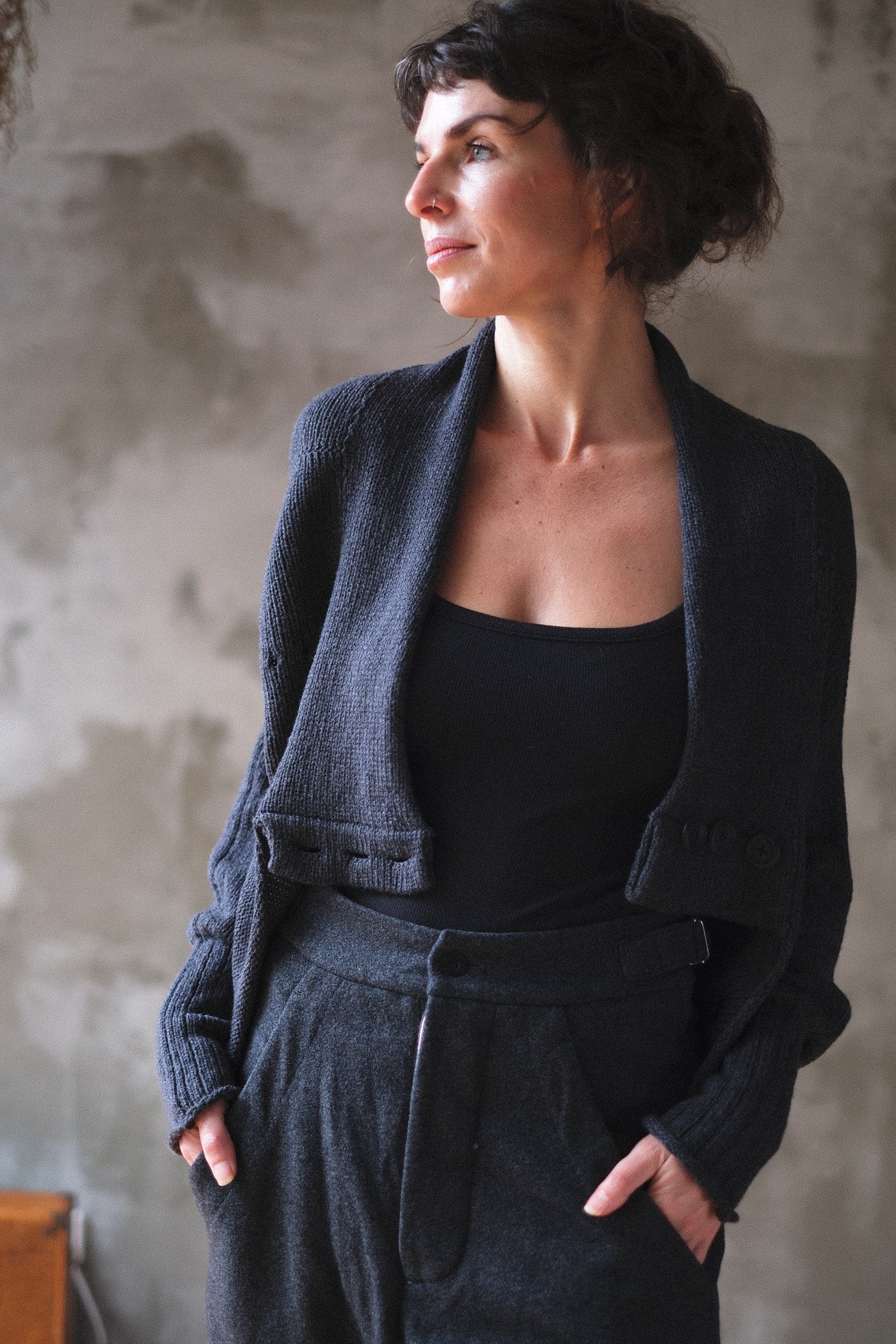 Models wears chunky knit charcoal cardi upside down.