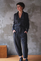 A woman wearing a charcoal gray chunky knit cardigan with 3 buttons.