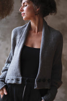 Model wears soft grey chunky knit cardi upside down.