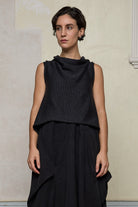 Model wears knitted charcoal asymmetric self curling vest, back to front. Designed and knitted in Melbourne by Wendy Voon knits