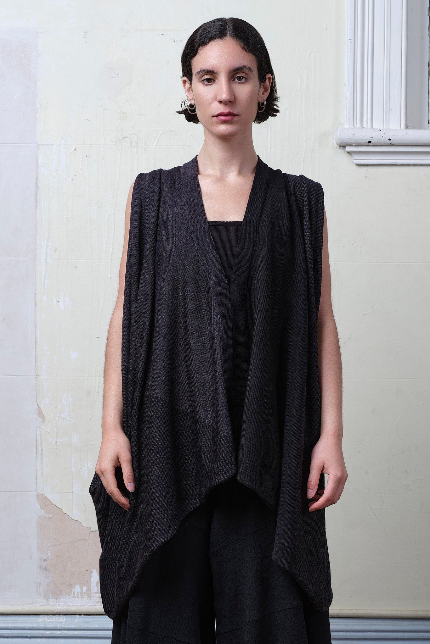 Model wearing a wool striped wrap in charcoal/black colourway. Designed and made in Melbourne by Wendy Voon knits.