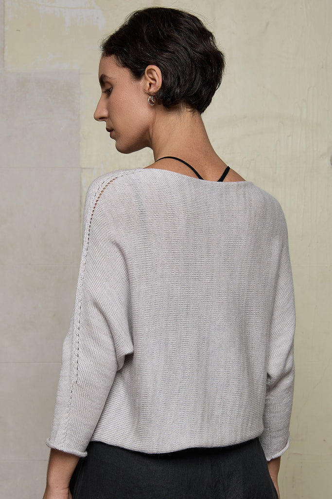 Back view of model wearing a knitted natural coloured batwing, designed and knitted in Melbourne by Wendy Voon knits