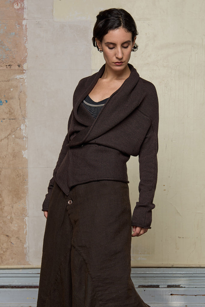 Model wears a knitted shawl collared cardigan pinned at the waist in a chocolate brown colourway.  Cardigan is designed and knitted in  Melbourne by Wendy Voon knits.